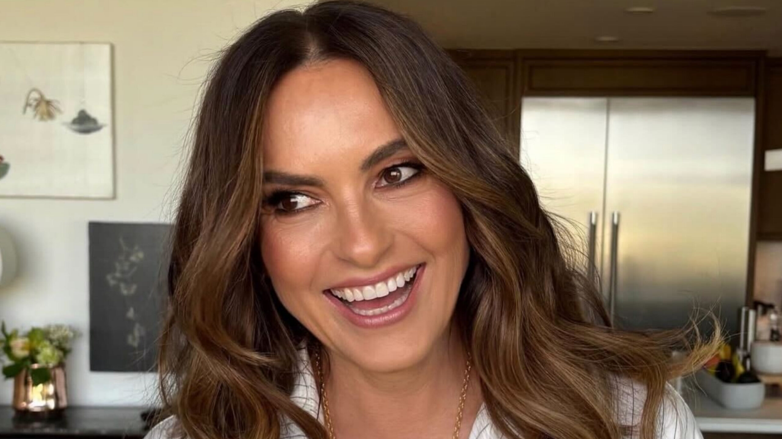 Close-up portrait of actress Mariska Hargitay smiling with wavy brown hair.